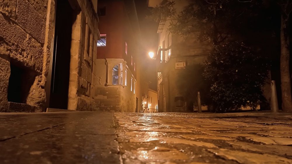 A rainy old european street at night.
