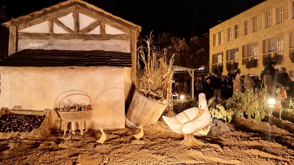 Another building of the nativity scene. A goose with her chicks is near a small pepper plantation.