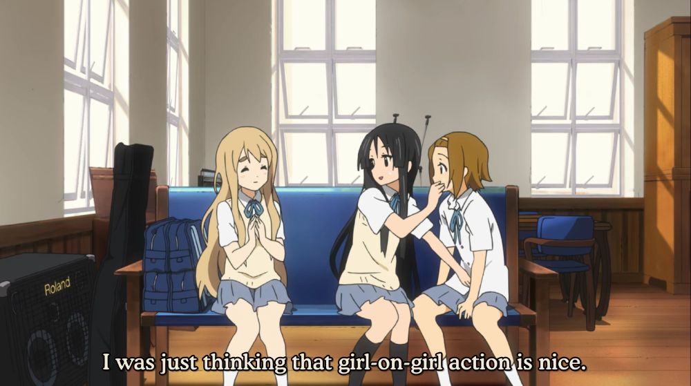 Mugi, Mio, and Ritsu from K-On! are sitting on a couch in the light music club clubroom, Mugi is saying "I was just thinking that girl-on-girl action is nice."