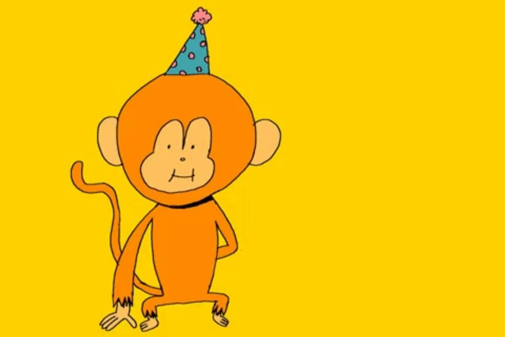 a monkey wearing a birthday hat is holding flowers