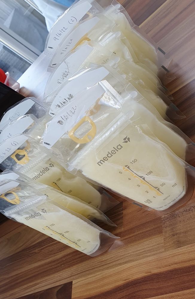 Colour image of around a dozen plastic breast milk storage bags filled with frozen expressed breast milk. 