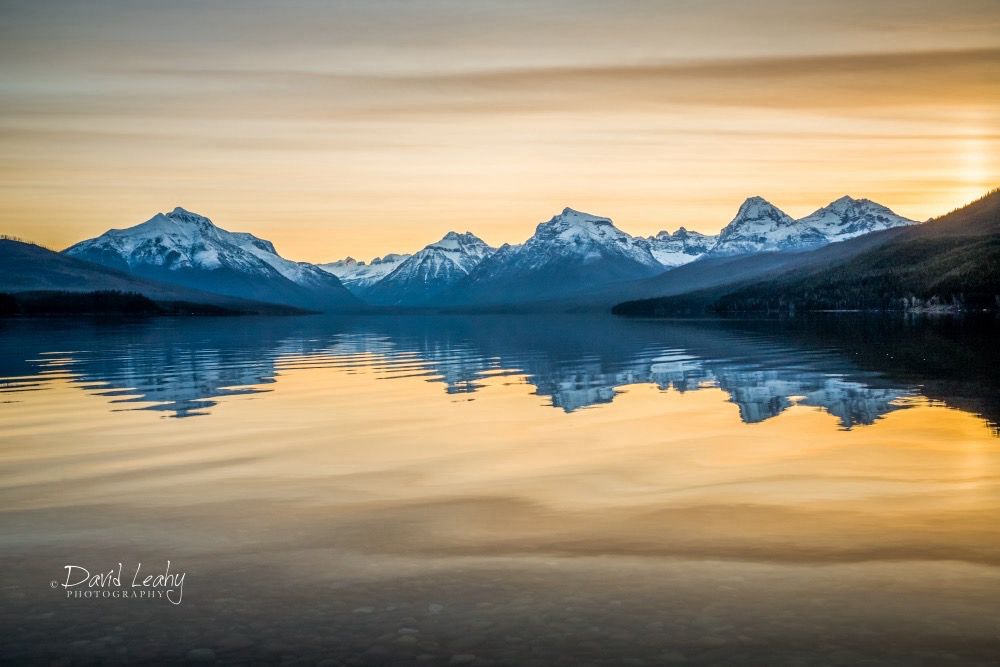 Sunrise reflected on Lake McDonald inside Glacier National Park.