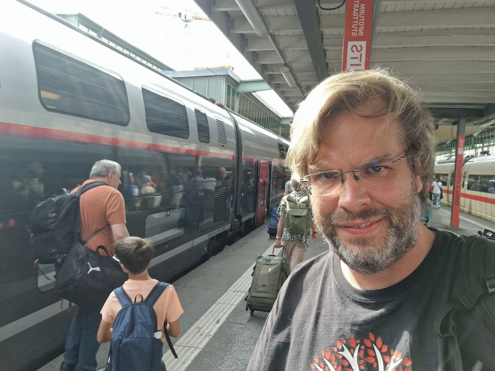 Me, besides a TGV at Stuttgart main train strain. It is overcast.