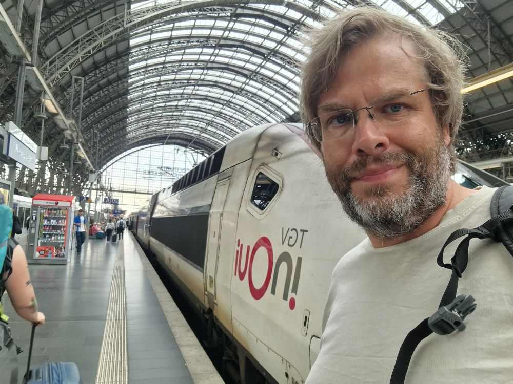 Me, besides a TGV, at Frankfurt main station. It is overcast.