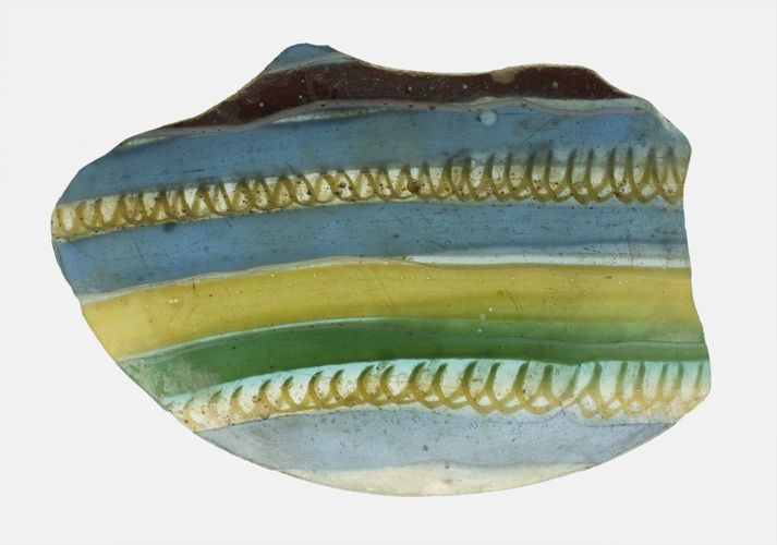 In ancient Rome, there was a high demand for colorful glass that could dazzle banquet guests alongside the expensive silver and gold serving wares meant to impress. Fragments like this one would have once been a part of larger mosaic dishes. The ribbon pattern was made by bundling rows of parallel rods of glass, which were then fused to create swirling patterns

Gift of Theodore W. and Frances S. Robinson