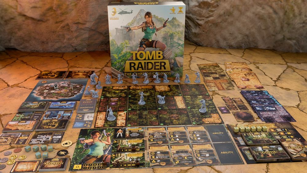 A packshot showing the layout of Tomb Raider: The Crypt of Chronos board game. It contains multiple game tiles, a Lara board, an island board, a craft board, many miniatures including Lara, wildlife enemies, mercenaries, the island protectors, and much more. 