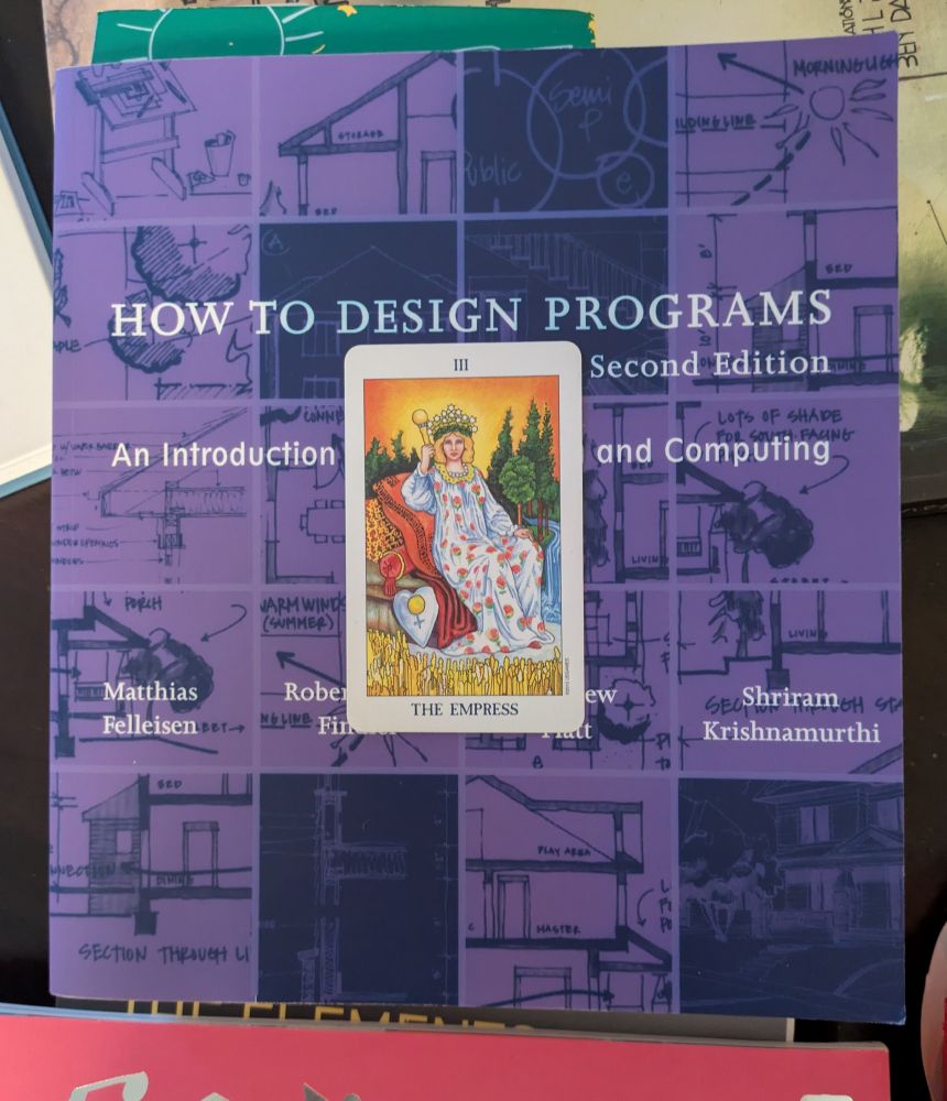 a physical copy of the How to Design Programs book and The Empress card