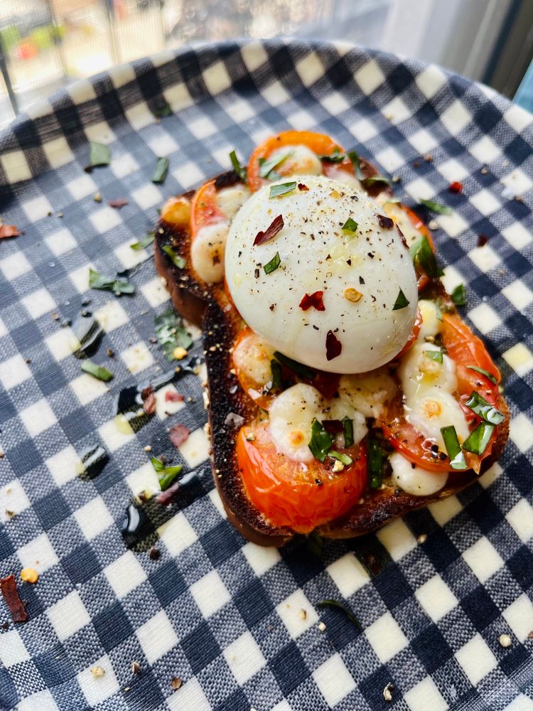 Pesto, mozz, tomatoes and fresh basil on toast topped with a gooey boiled egg