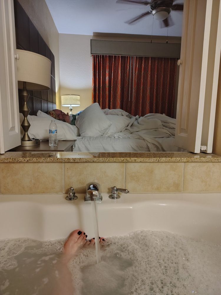 We got a hotel in Orlando for a staycation and the only speculation for the hotel was that we wanted a jacuzzi tub in the room. So this is me, in the tub absolutely luxuriating and looking at my partner through a little window from the tub to the master bedroom. It was such a cute room and they gave us free pizza and terrible drinks! 😂
