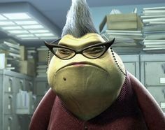 A picture of the character Roz from the animated movie Monsters Inc. Roz is a giant greenish yellow slug, with grey hair in a Mohawk style. She is wearing a red cardigan sweater and black horn-rimmed glasses. She has a bit of red lipstick on. She looks very annoyed. 