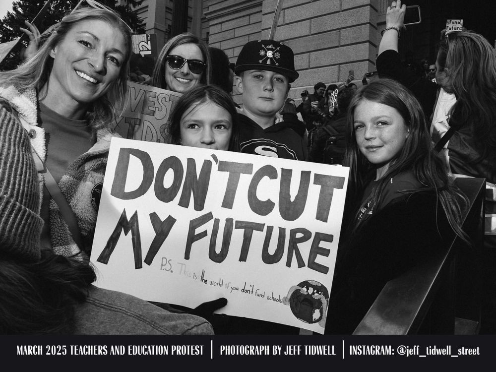 June 20th, 2025: A photograph by Jeff Tidwell that shows local activists at a protest holding a sign that states, "Don't Cut My Future P.S. This is the world if you don't fund schools" with an image of the earth crying. The caption of the photograph states the image was taken in March 2024 during the Teachers and Education protest. Jeff's Instagram is given as @jeff_tidwell_street