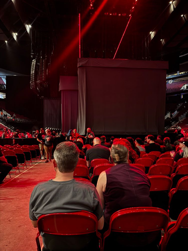 picture of two covered stages with people in seats and empty seats also.