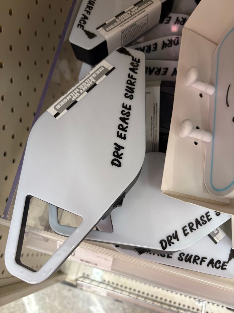 A vaguely surfboard-shaped box with a white plastic top labeled “dry erase surface” in a font that makes “surface” read as “surf ace”