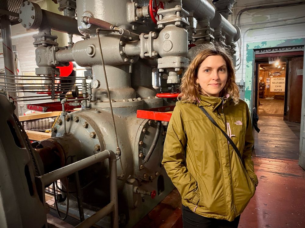 A photo of a woman in front of industrial machinery 