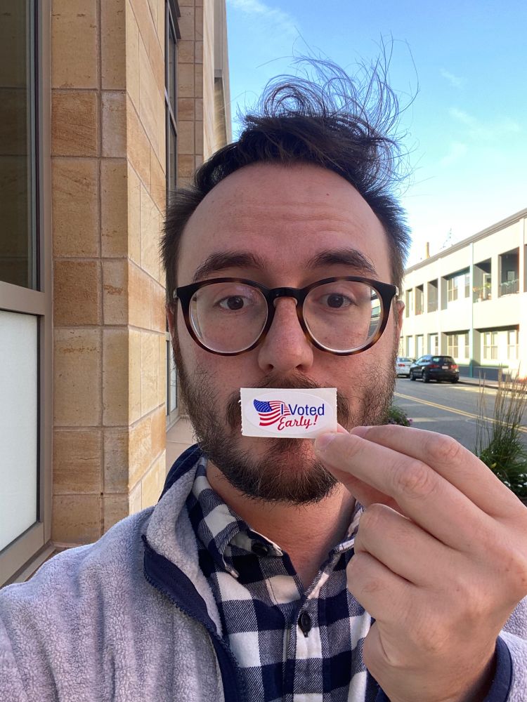 A selfie holding a “I voted early!!” Sticker