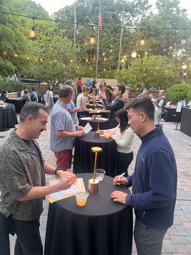 This is a set up of speed friend with two people standing at a cocktail and other similar tables behind them