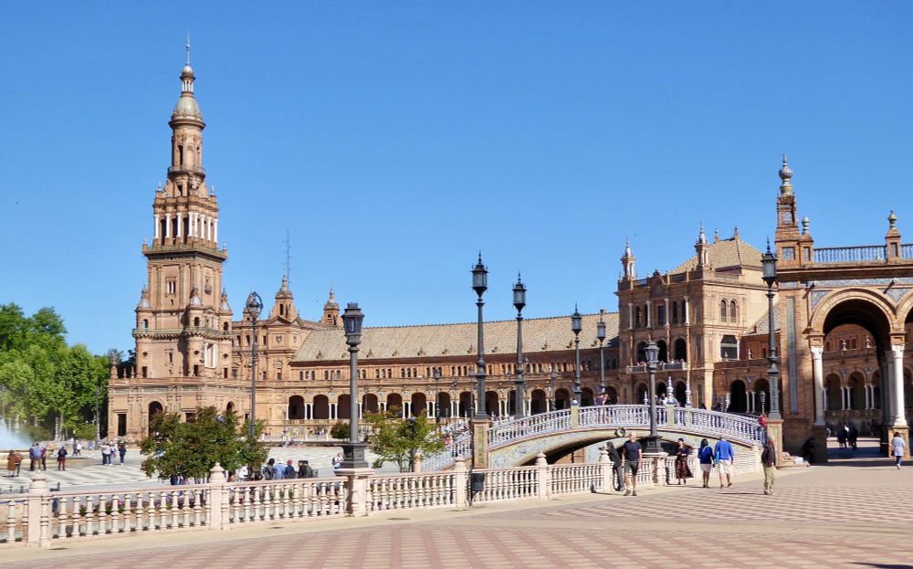 Vista parcial de la plaza de España. Farolas, puente y edificio al fondo. Cielo azul