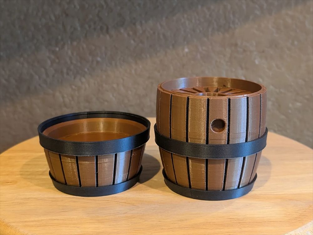 Photo of a 3D printed barrel for storing Nintendo Switch cartridges. The lid is currently open.