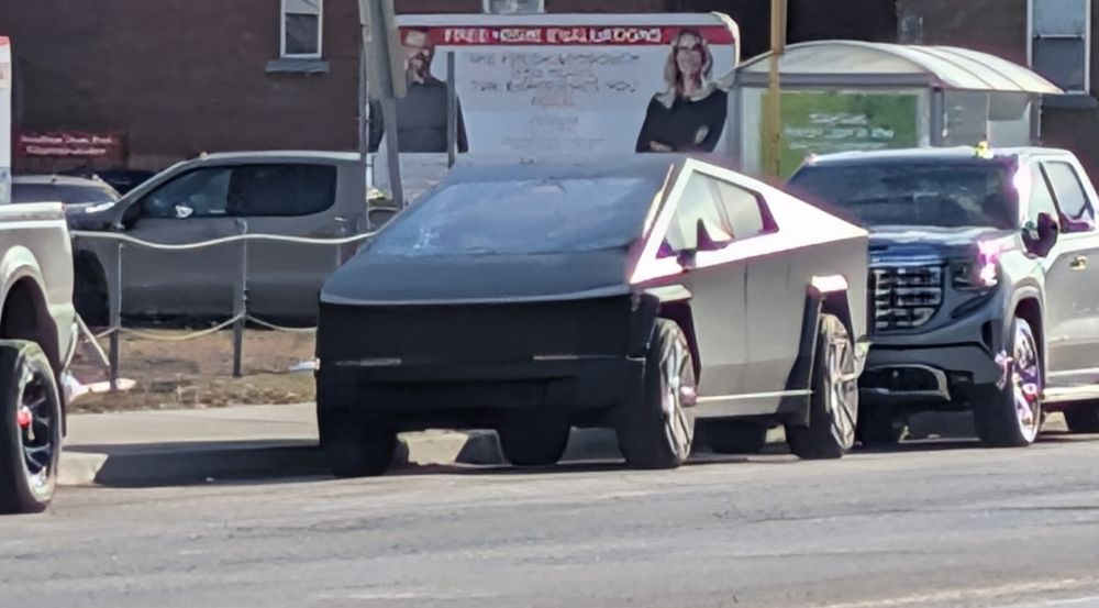 an image of a cybertruck parked streetside. it has frost covering the panels