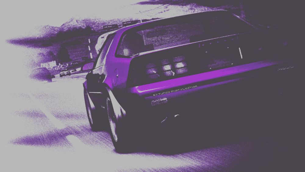 A heavily edited image of a 1990 Camaro driving quickly down a highway. Every colour has been filtered into black and white, with the only colour in the image being the purple Camaro.