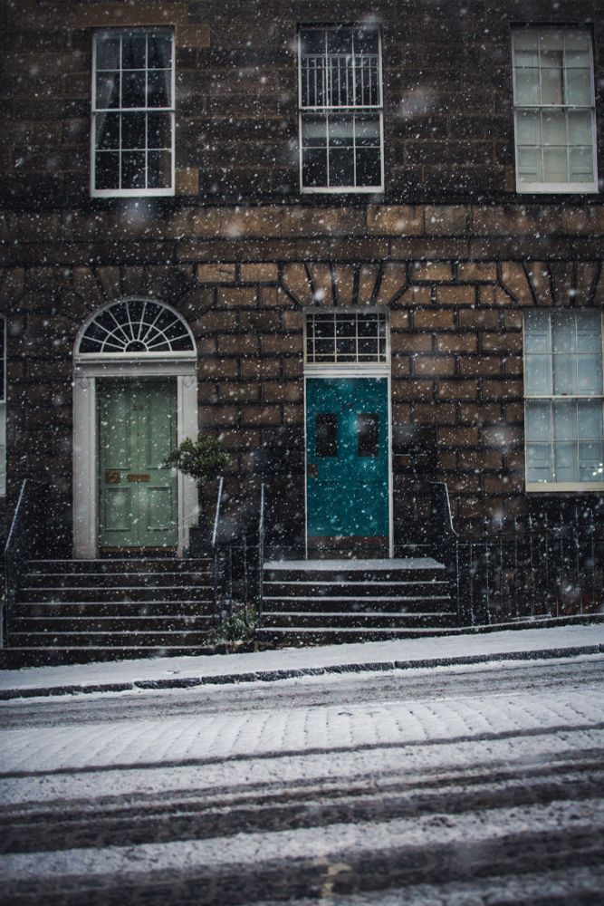 Snow falling in front of colourful doorways
