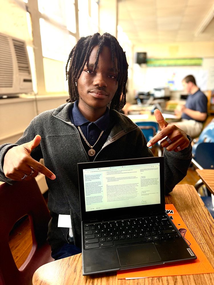 Student points to laptop showing off his thesis 