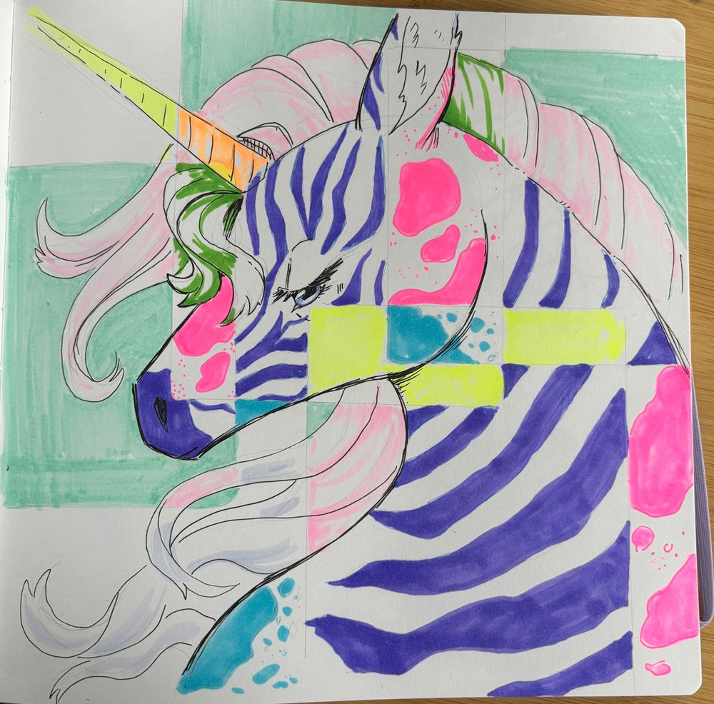 Photo of marker sketch in a sketchbook. Shows four squares breaking up a unicorn head and neck into shapes and colors. 
