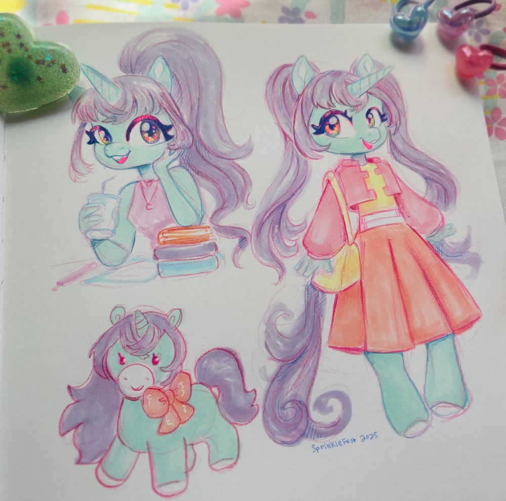 A photo of three sketches of unicorns inside a sketchbook. Top left is a green unicorn with a purple ponytail taking a break from working on a paper. They have a drink in one hand and are resting the other arm on a stack of books. The right unicorn is the same character with pigtail hair style, a pink jacket over a yellow shirt and a long orange skirt with a yellow bag. The bottom left unicorn is a plush like stylized version of the unicorns above and wearing a orange bow. The signature at the bottom says Sprinklefest 2025.