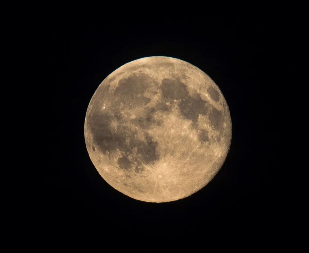 a pic of a golden moon on a black background(space)