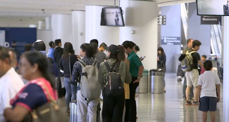 Travelers walk through the terminal at an airport.