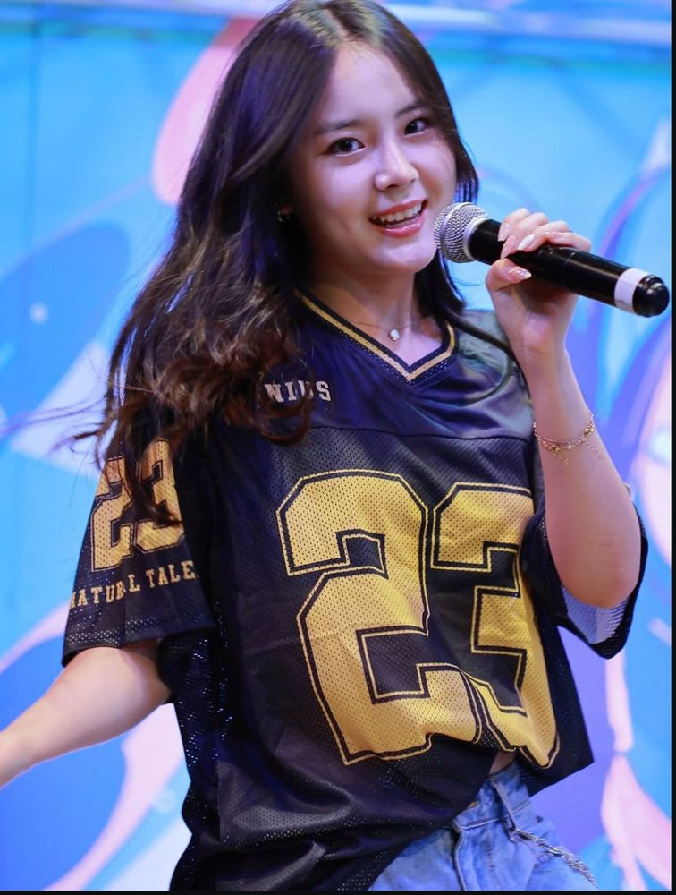 Looks from Kandis mid performance, smiling at the camera in an oversized blue jersey :)
