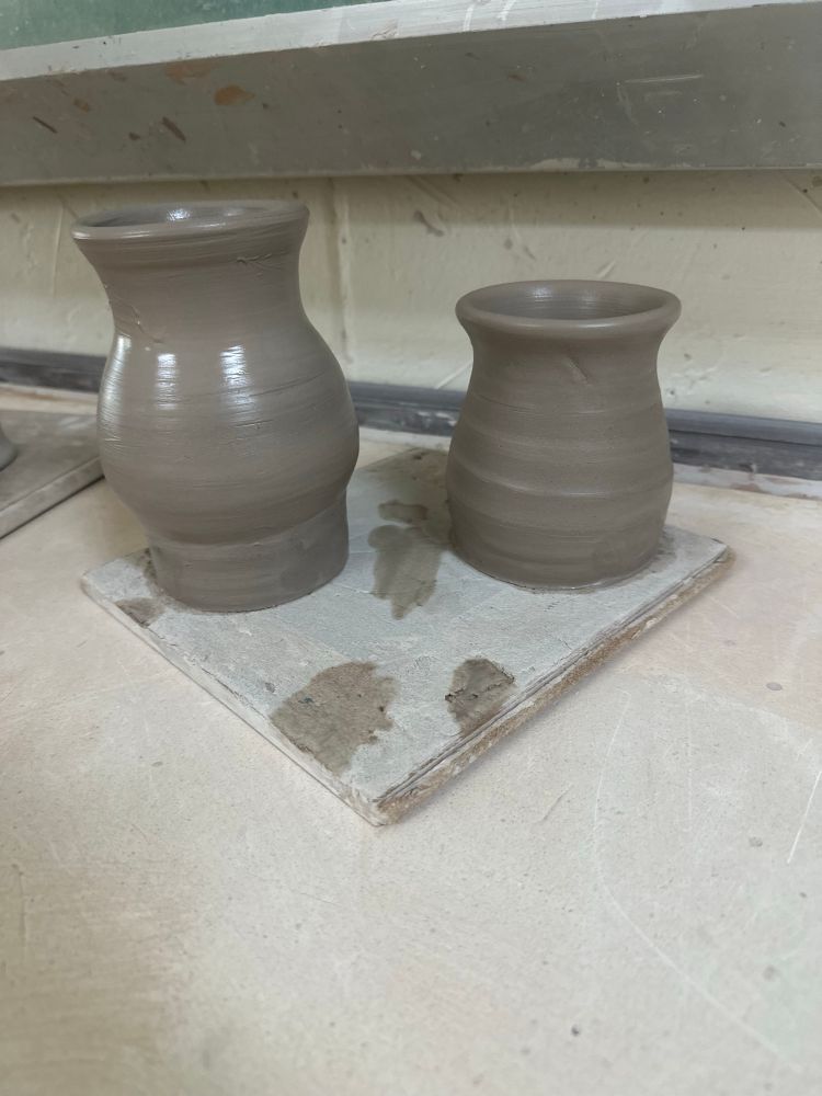Two medium sized clay bodies, still wet, made with earthenware clay. 