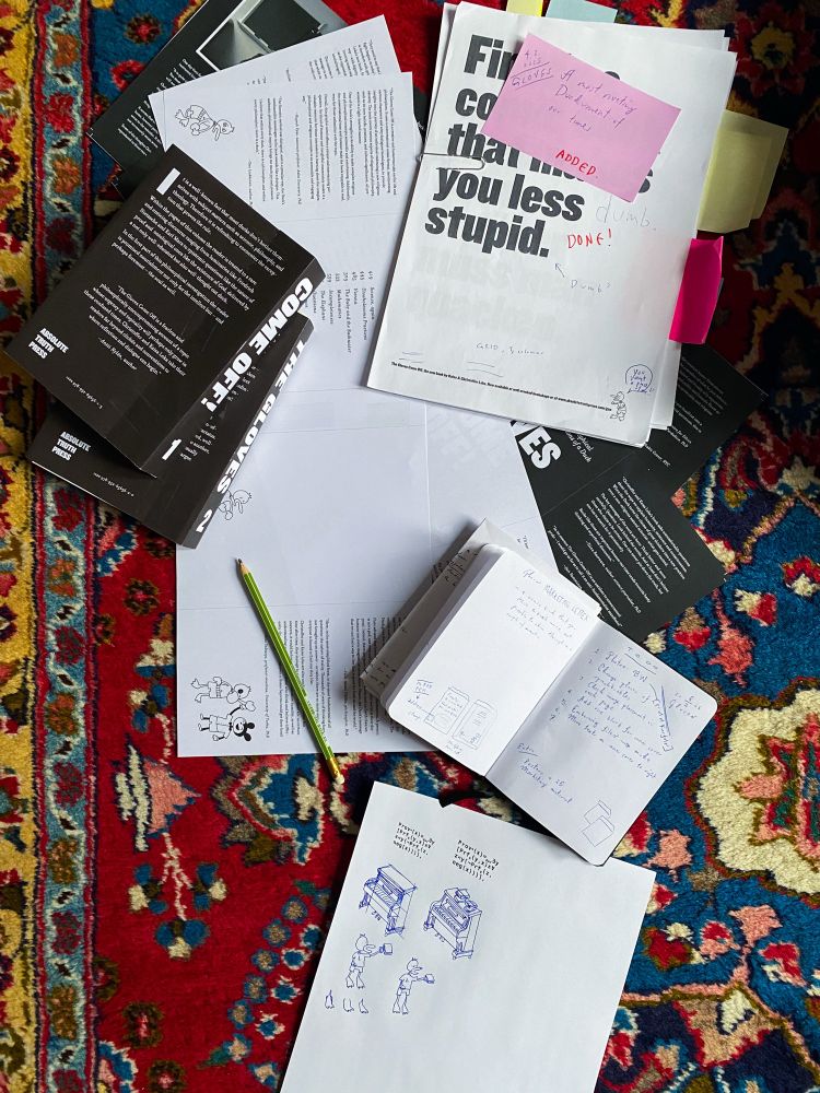 A pile of prints and sketches scattered on a colorful rug.