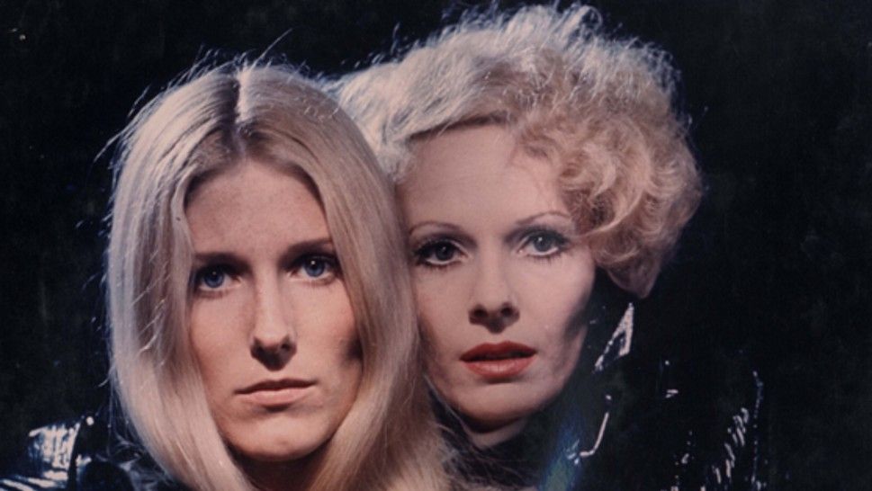 Two blonde women -- one a little younger, the other a little older -- peer at something out of frame, lit from above like an '80s Bonnie Tyler album cover. (Which is nifty, because the image was taken in 1971.)