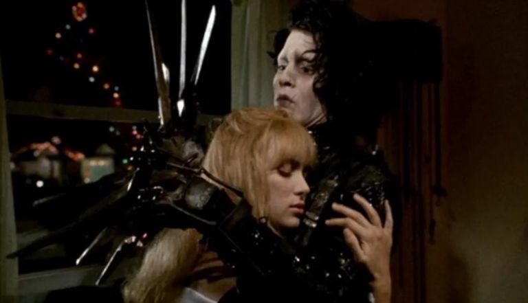 A young woman embraces a pale-faced man with long, sharp blades where his fingers should be. He appears concerned.

(Image is of Winona Ryder and Johnny Depp in EDWARD SCISSORHANDS.) 