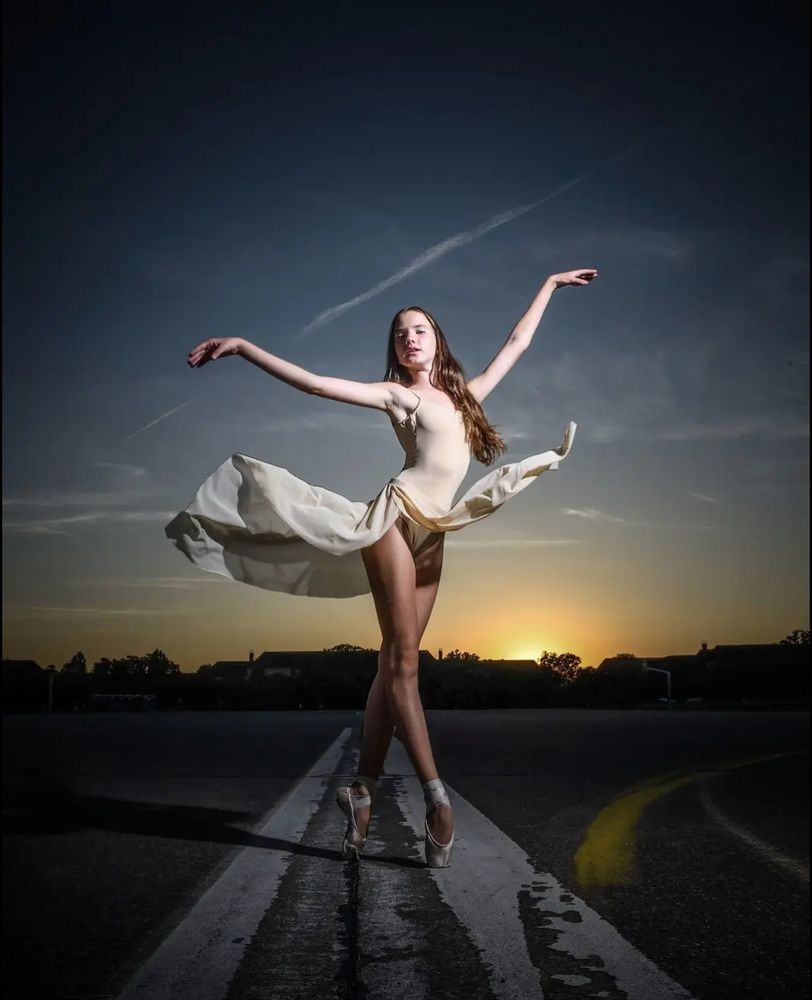 Alexa Kail, ballerina, dancing on the pavement street as dawn breaks behind her
