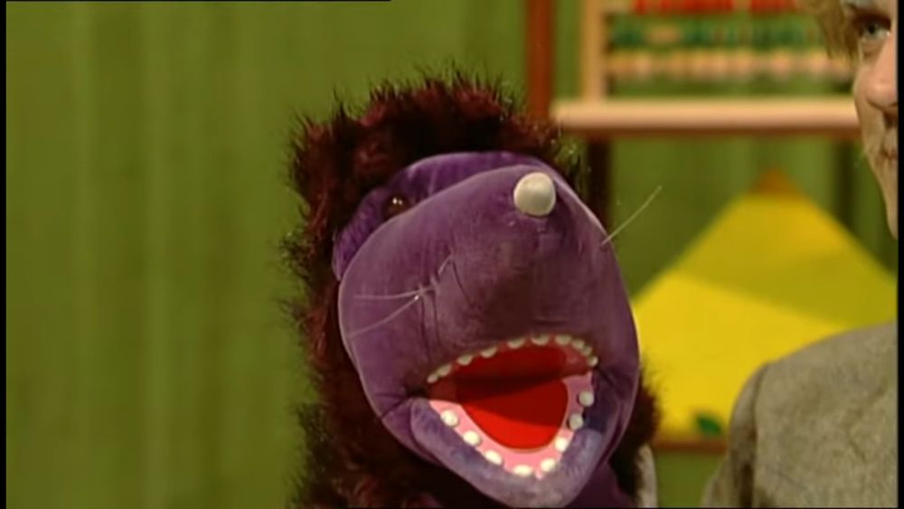 Photo of the Decimole (a purple mole puppet) smiling