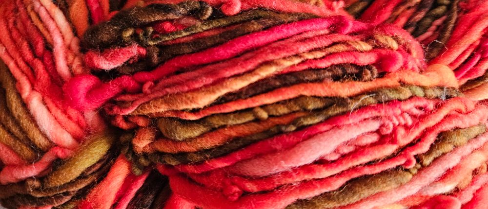 Shades of vibrant reds & oranges swirling with rich earthy browns make up this 100% Rambouillet Wool. At 4oz this spun up to 175.5 yards. BIG SMILE.