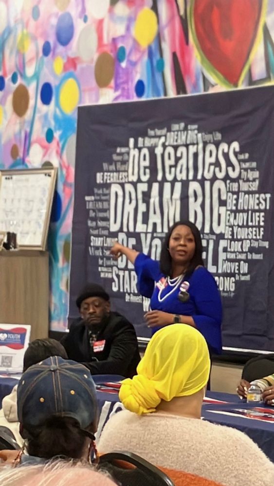 E speaking emphatically on stage