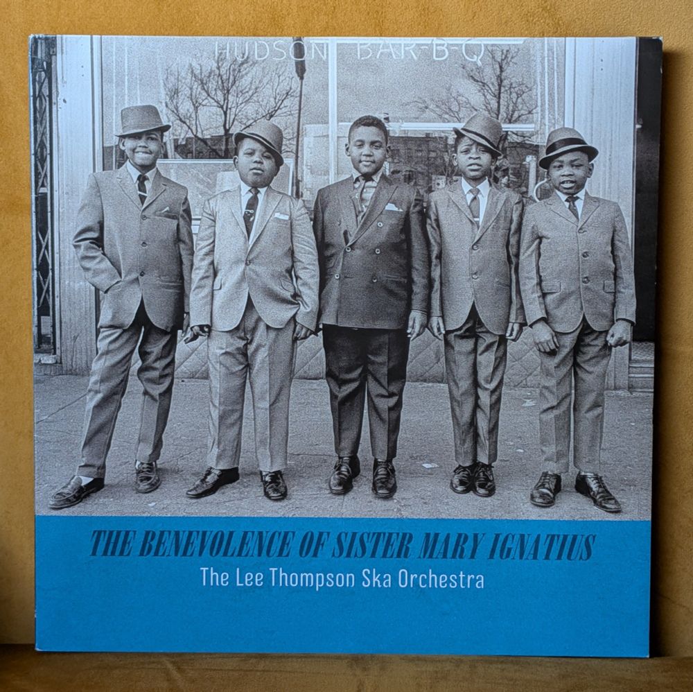 A photo of a vinyl album cover showing a group of young teenage Jamaican boys dressed in sharp suits and ill fitting shoes, probably boys from The Alpha Boys School 
