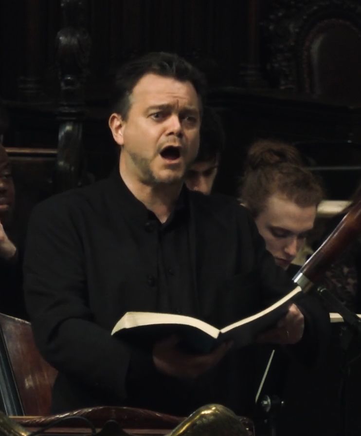 Tenor Charles Blandy singing with score in hand (probably Bach)