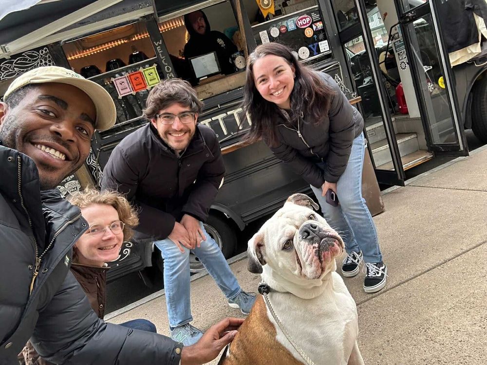 A group of people with the Yale mascot Handsome Dan in front of a coffee truck.