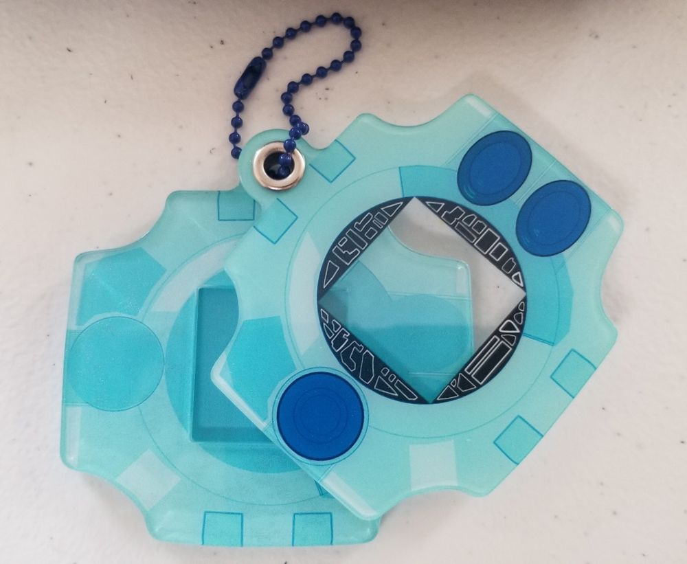 Digivice keychain with a small photo compartment shown partially opened