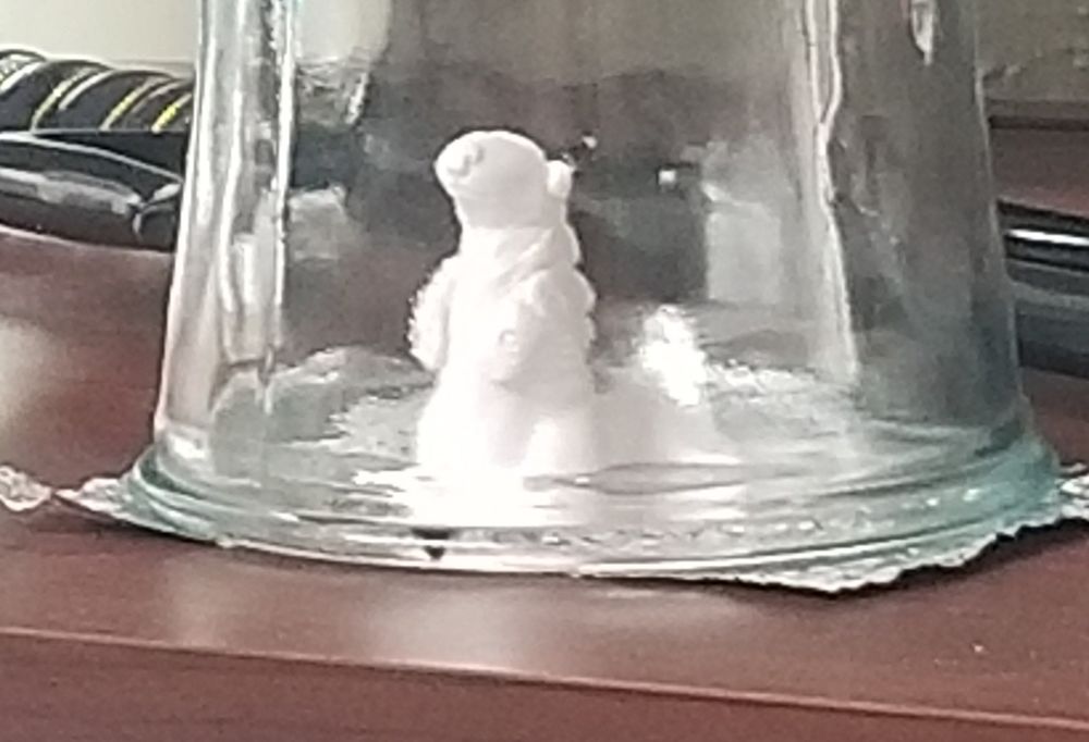 Nondescript (blurry) polymer clay sculpture underneath an overturned vase