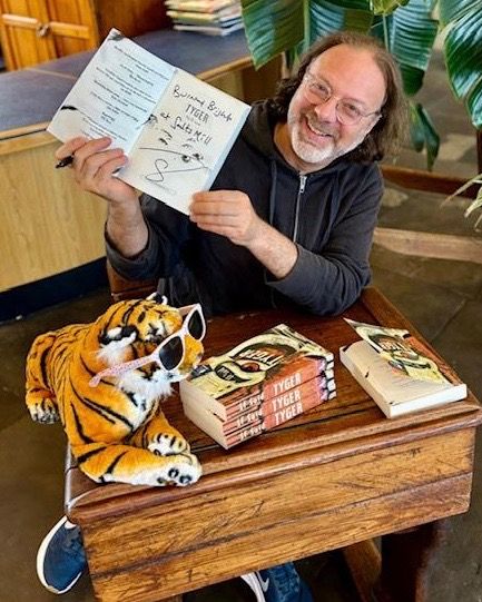 Author SF Said with copies of his book Tyger, illustrated by Dave McKean, at the bookshop in Salts Mill, Saltaire. Also pictured is a brilliant bookshop tiger with sunglasses!