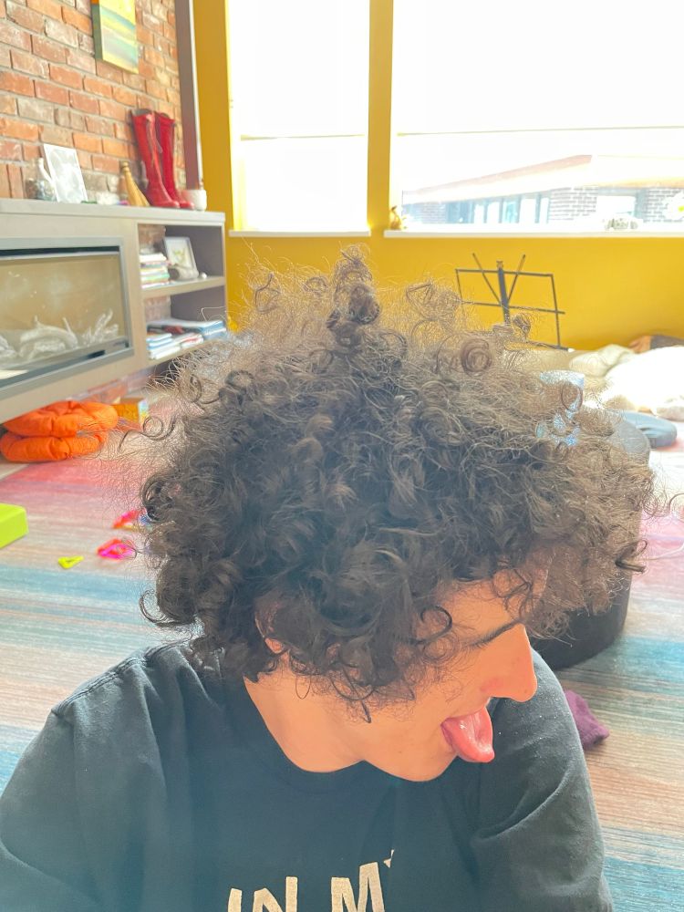 Wild curly hair we we trying to grow out.
