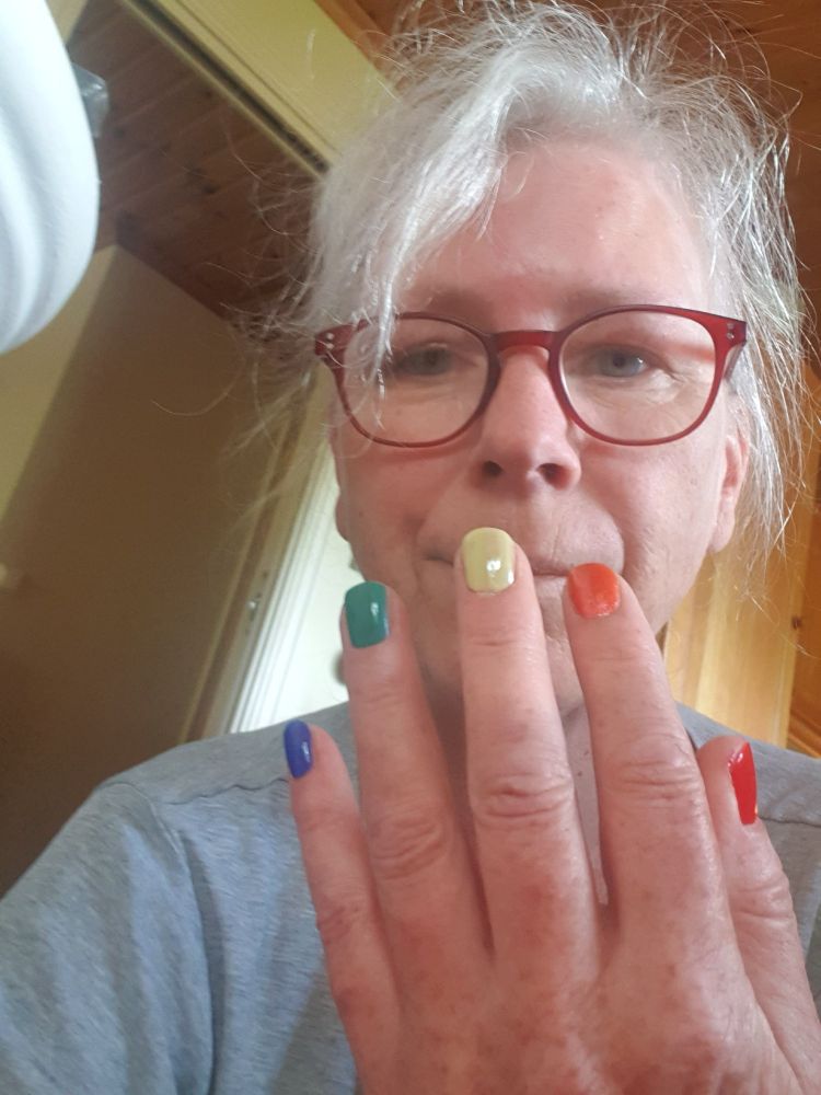 Meg som holder opp nylakkerte negler forran ansiktet