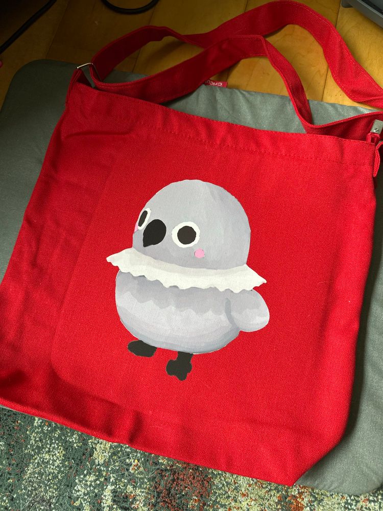 A grumpy crow painting by corrin on a bright red tote bag