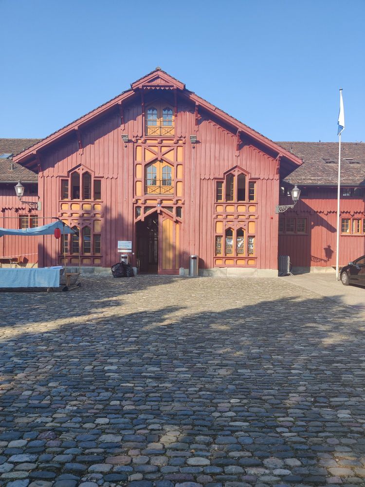 An entrance of a large red, wooden building.
