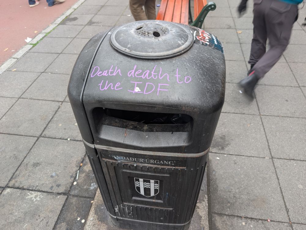 A trash can on which someone has written, 